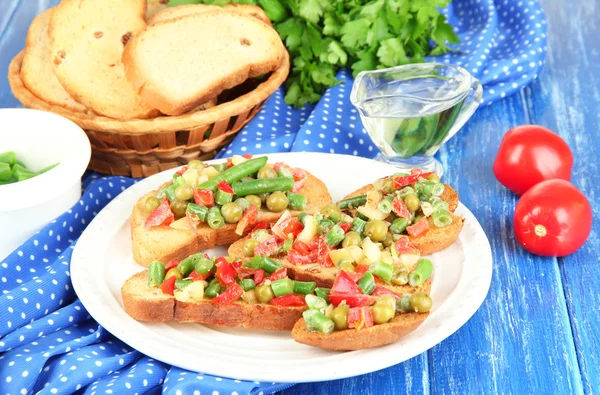 Sandwiches with vegetables and greens on plate on wooden table close-up — Stock Photo, Image