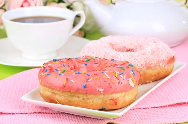 Sweet donuts with cup of tea on table close-up — Stock Photo, Image