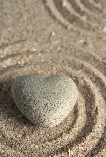 Pietra zen grigia a forma di cuore, su sfondo di sabbia — Foto Stock