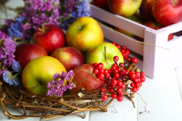 Saftige Äpfel in Schachtel auf weißem Holztisch — Stockfoto