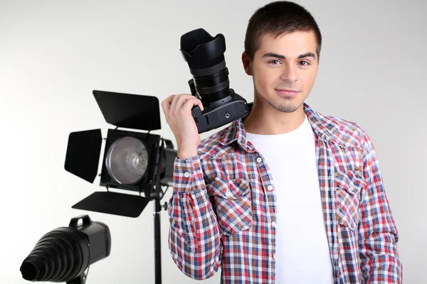Stilig fotograf med kamera, på foto studio bakgrund — Stockfoto