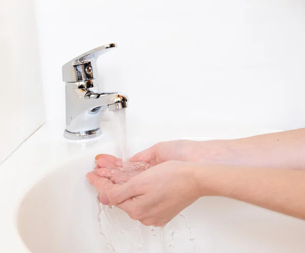 Nahaufnahme menschlicher Hände, die unter dem Wasserhahn im Badezimmer gewaschen werden, isoliert auf weiß — Stockfoto