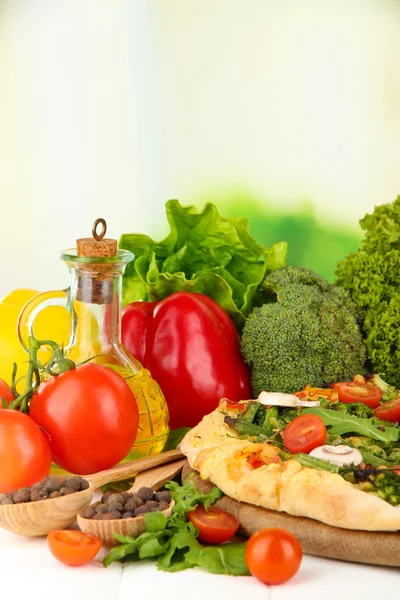 Tasty vegetarian pizza and vegetables on wooden table — Stock Photo, Image