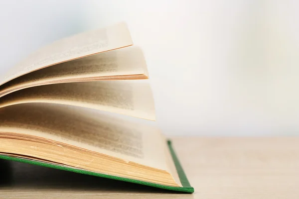 Opende boek op houten tafel op lichte achtergrond — Stockfoto