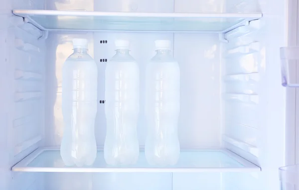Flessen met water in de koelkast — Stockfoto