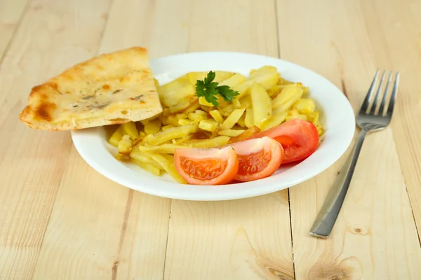 Жареный картофель на тарелке на деревянном столе крупным планом — стоковое фото