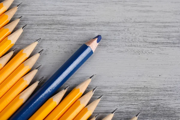 Festliga penna bland vanliga pennor, färg bakgrunden — Stockfoto