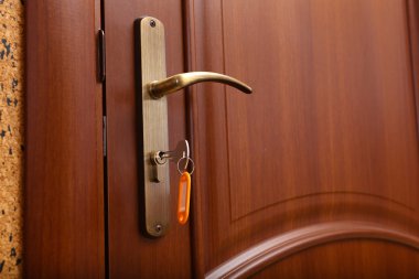 Elinde anahtarla kapıyı kilitlemek ya da açmak.