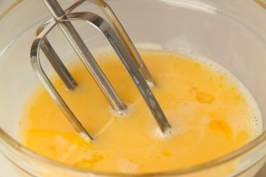 Yemek, yumurta bir kapta elektrikli çırpma teli ile kırbaçlanan, yakın çekim