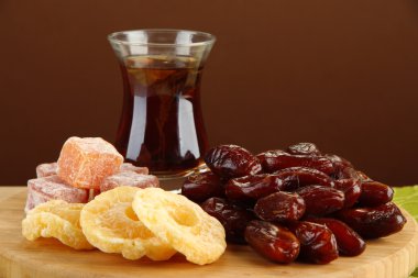 kahverengi zemin üzerinde masa üzerinde çay ve tatlılar fincan kuru hurma
