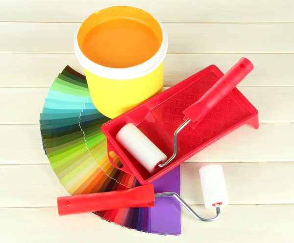 Για ζωγραφική: Χρωματίστε ποτ, roller-χρώμα στο λευκό ξύλινο τραπέζι — Φωτογραφία Αρχείου
