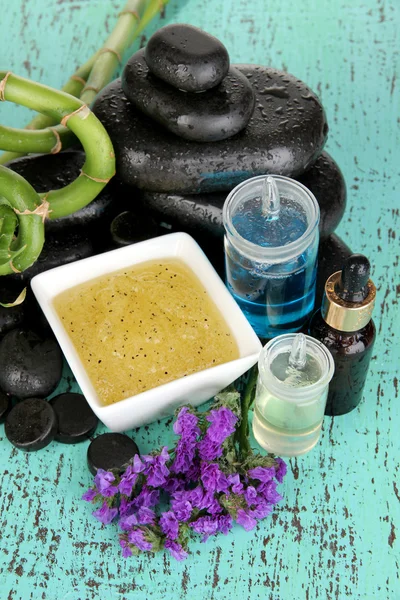 Spa composition with oils and spa stones on wooden table close-up