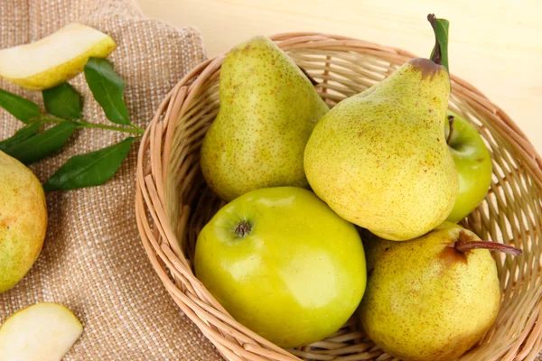 Pears in basket on burlap on wooden table — Stock Photo, Image