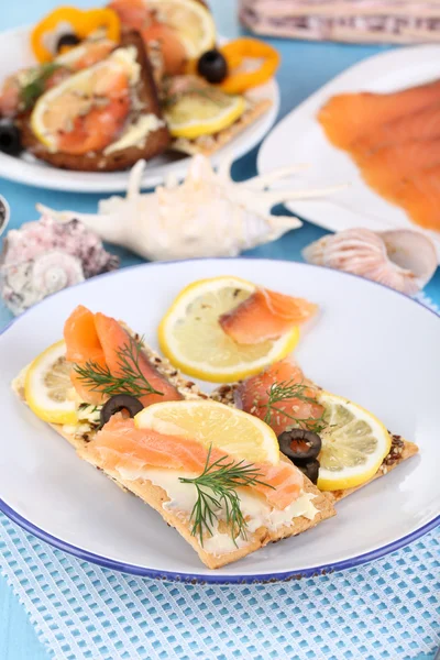 Sanduíches de salmão na placa na mesa de madeira close-up — Fotografia de Stock