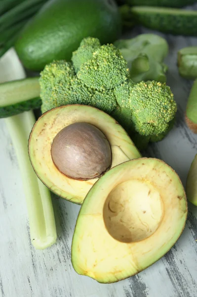 Свежие зеленые овощи и фрукты на деревянном фоне — стоковое фото