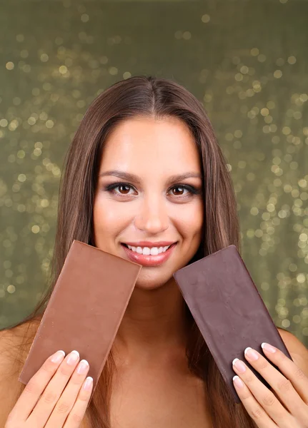 Portrait of beautiful young girl with chocolate on shiny background — Stock Photo, Image