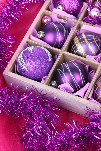 Brinquedos de Natal em caixa de madeira no fundo brilhante — Fotografia de Stock