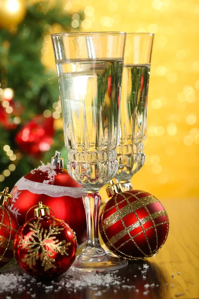 Composition with Christmas decorations and two champagne glasses, on bright background — Stock Photo, Image