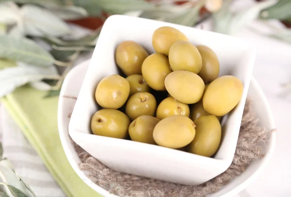 Olives in bowl with branch on napkin close-up — Stock Photo, Image