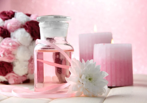 Glazen flesje met kleur essentie, op roze achtergrond — Stockfoto