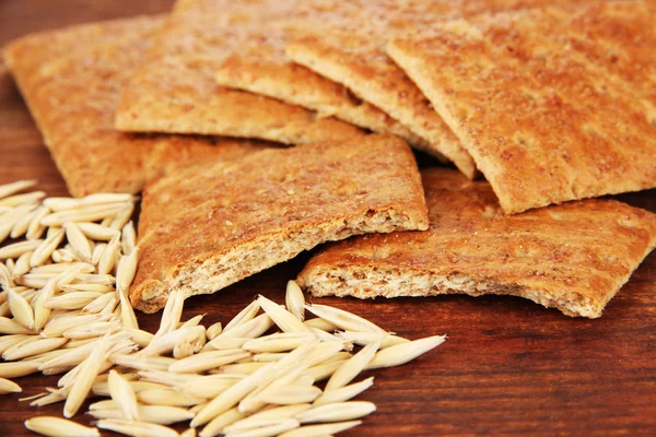 Heerlijke crackers met maïs op houten tafel op rouwgewaad achtergrond — Stockfoto