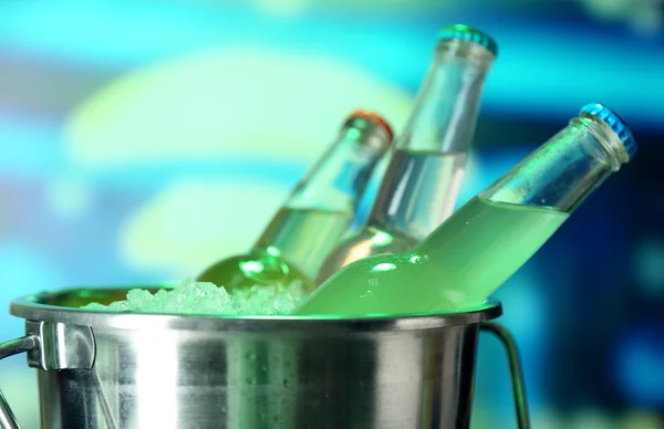 Bebidas embotelladas en cubo de hielo sobre fondo brillante —  Fotos de Stock