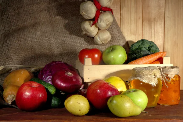 Composición de diferentes frutas y verduras en la mesa sobre fondo de saco — Foto de Stock