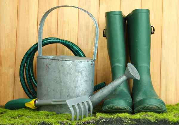 Herramientas de jardinería sobre hierba sobre fondo de madera — Foto de Stock