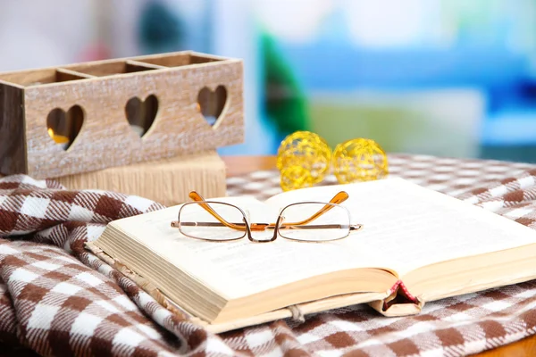 Composition with old book, eye glasses, candles, and plaid on bright background — Stock Photo, Image