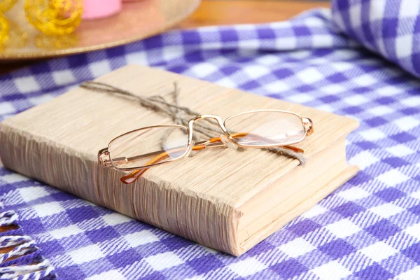 Composizione con vecchio libro, occhiali da vista e plaid su sfondo di legno — Foto Stock