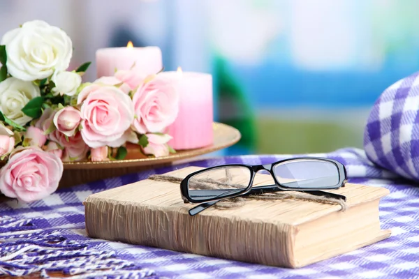 Composition with old book, eye glasses, candles, flowers and plaid on bright background — Stock Photo, Image