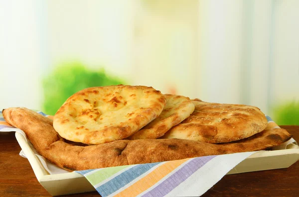 Pita breads on tray on table on bright background — Stock Photo, Image