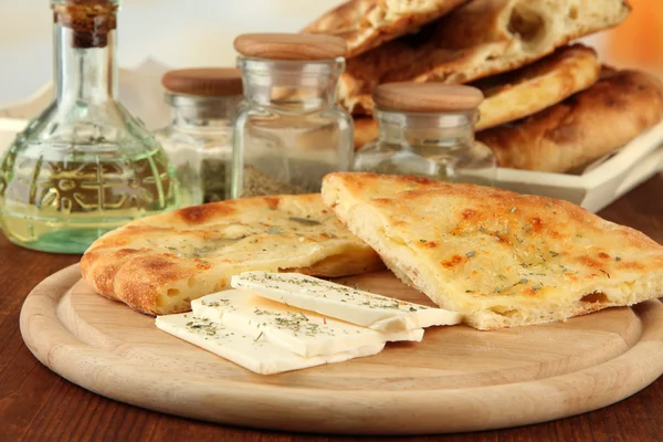 木製のスタンドの上にチーズと明るい背景にテーブルの上のスパイスとピタのパン — ストック写真