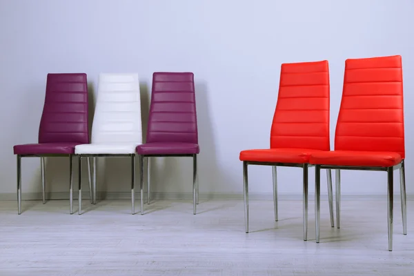 Modern renkli sandalyeler duvar zemin üzerine — Stok fotoğraf