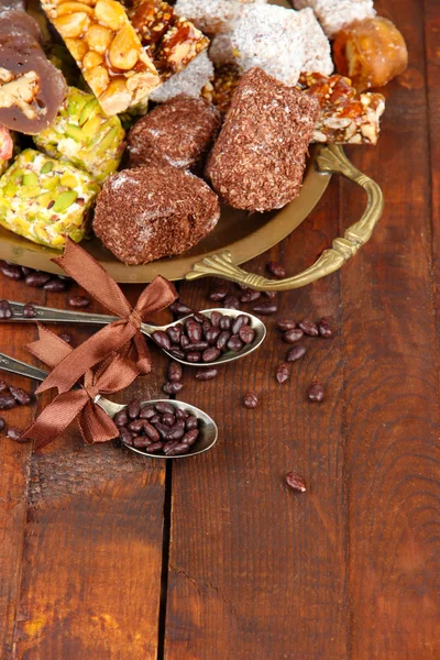 Smakelijke oosterse snoepjes op het dienblad, op grijze houten achtergrond — Stockfoto