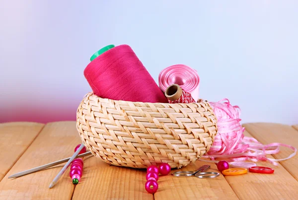 Handicraft supplies in basket on wooden table on bright background — Stock Photo, Image