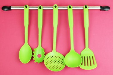 Plastik mutfak eşyaları üzerinde kırmızı zemin üzerine gümüş kanca