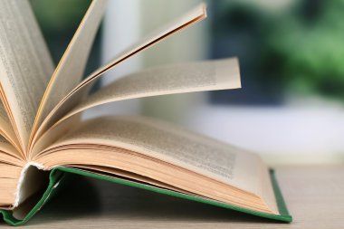 parlak zemin üzerine ahşap masa kitap açıldı