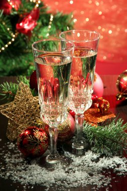 Yılbaşı süsleri ve parlak zemin üzerine iki şampanya bardağı kompozisyonu