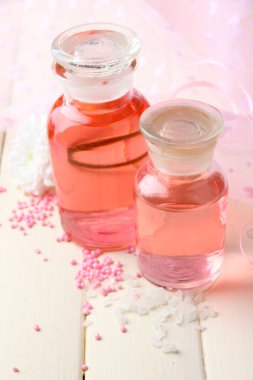 pembe bir arka plan üzerinde renkli özü ile cam şişe