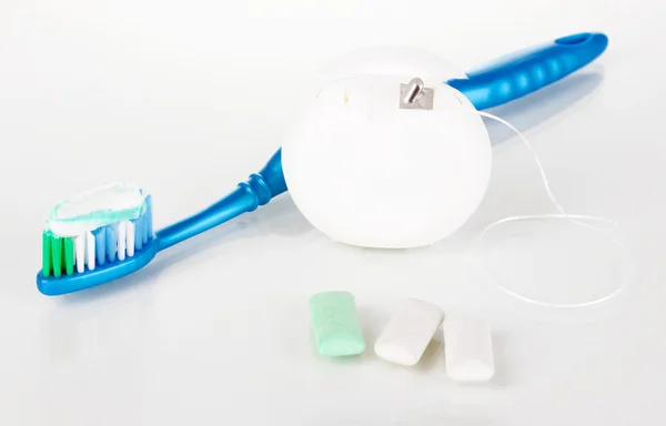 Toothbrush, chewing gum and dental floss isolated on white — Stock Photo, Image