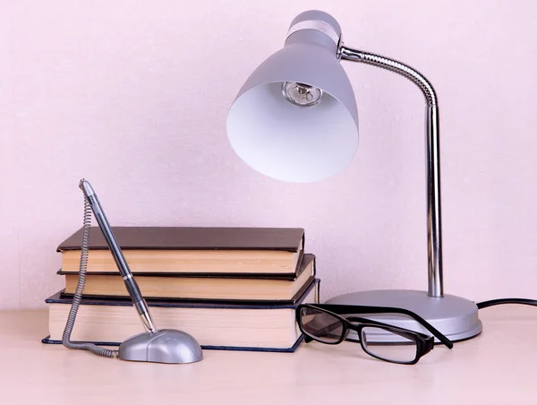 Tischlampe mit Büchern auf dem Schreibtisch im Zimmer — Stockfoto