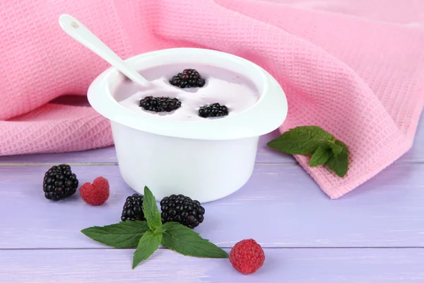 Смачний йогурт з ягодами на столі крупним планом — стокове фото
