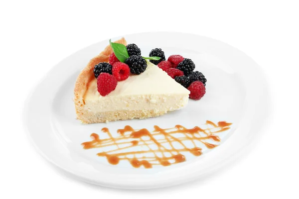 Slice of cheesecake with berries and sauce on plate, isolated on white — Stock Photo, Image