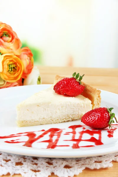 Rebanada de pastel de queso con fresa en el plato, sobre fondo brillante — Foto de Stock