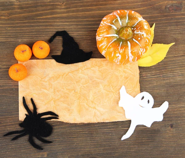 Old paper with Halloween decorations on grey wooden background — Stock Photo, Image