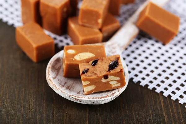 Viele Toffee in Holzlöffel auf Serviette auf Holztisch — Stockfoto