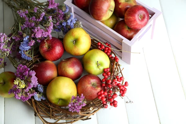 Saftige Äpfel in Schachtel auf weißem Holztisch — Stockfoto