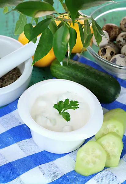 Gurka yoghurt i skål, på färg Servett, på trä bakgrund — Stockfoto