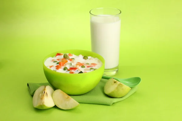 Tasty dieting food and glass of milk, on green background — Stock Photo, Image